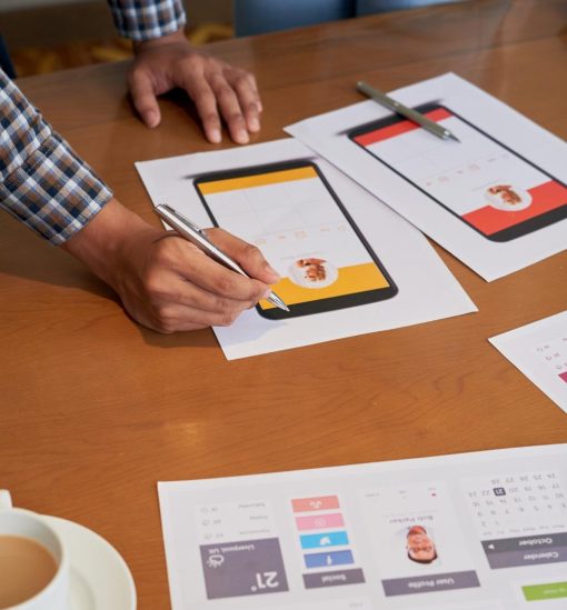 collegues-meconnaissables-debout-table-regardant-projets-conception